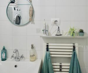 een witte badkamer met een wastafel en een spiegel bij Il Mono del Porto - Studio Apartment in Ancona