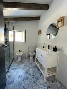 a bathroom with a sink and a toilet and a mirror at Black Wood Cabin in Mărişel +35 photos