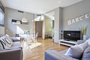 a living room with two couches and a tv at Hotel Acta Laumon in Barcelona