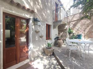 a patio with a table and chairs and a door at Cortile Via Sales 11 in Erice