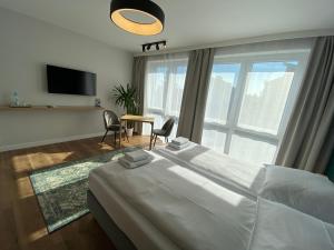 a bedroom with a large bed and a large window at InvestRooms in Gdańsk