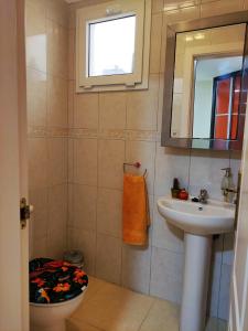 een badkamer met een wastafel, een toilet en een spiegel bij Casa Confort in Los Abrigos