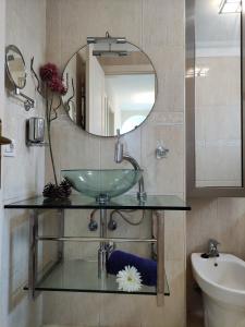 y baño con lavabo de cristal y espejo. en Casa Confort, en Los Abrigos