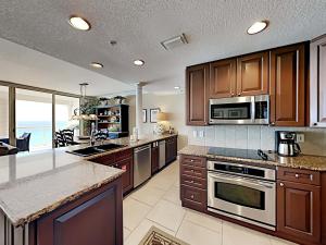 a kitchen with wooden cabinets and a counter top at Beach Club 904c in Pensacola Beach