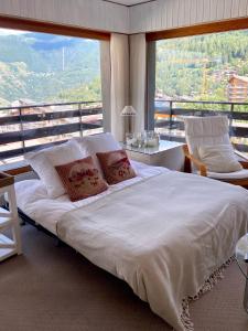 a large white bed in a room with a large window at Sunny mountain view apartment in town by Jolidi in Nendaz