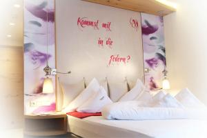 a room with two beds and a wall with writing on it at ... mein romantisches Hotel Toalstock in Fiss