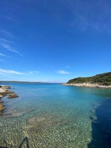 um grande corpo de água com pedras e uma praia em Casa Bellavista em Nerezine