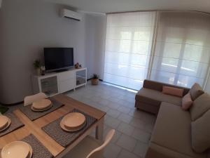 een woonkamer met een bank en een tafel bij Bonaria Apartment in Cagliari