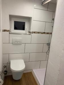 een witte badkamer met een toilet en een raam bij Ferien im Kayserreich in Reichelsheim