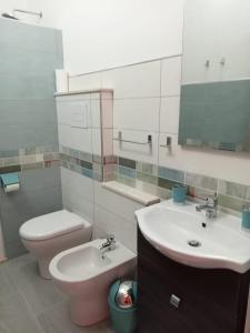 a bathroom with a sink and a toilet and a mirror at Lungomare Bed rooms in Santa Maria Navarrese +25 photos
