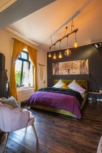 a bedroom with a bed with purple sheets and a window at Boutique Apartments Benz I-III in Bergisch Gladbach