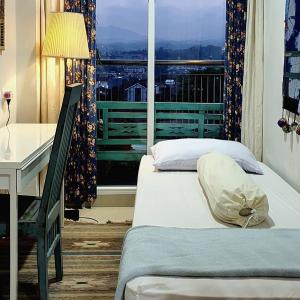 - une chambre avec 2 lits, un bureau et une fenêtre dans l'établissement 1010 - Bohemian Apartment, à Bandung