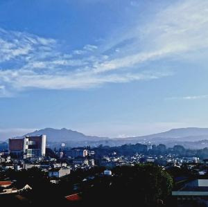 a view of a city with mountains in the background at 1010 - Bohemian Apartment in Bandung