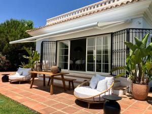 um pátio com uma mesa, 2 cadeiras e uma mesa em VILLA DE LA LUZ Luxury Guesthouse em El Portil