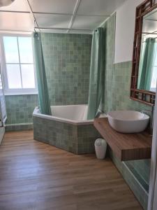 une salle de bain carrelée verte avec une baignoire et un lavabo dans l'établissement Maison de pêcheur typique proche plage, à Fécamp 15 autres photos