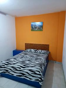 een bed in een kamer met een oranje muur bij HOTEL CASA XION in Neiva