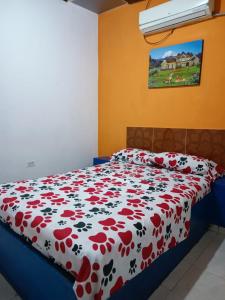 een slaapkamer met een bed met een rode en witte deken bij HOTEL CASA XION in Neiva