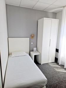 a bedroom with a bed and a cabinet at Hôtel P.L.M. in Cannes