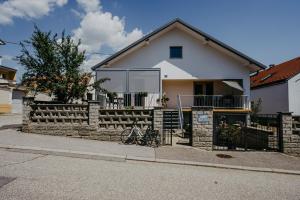 a house with a fence and a bike parked in front at Auszeit Neusiedlersee in Mörbisch am See