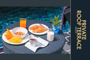 una mesa con platos de comida y bebidas. en 3 BR Stylish Condo with Private Rooftop Pool, en Kamala Beach