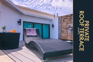 un patio con 2 sillas y una mesa en 3 BR Stylish Condo with Private Rooftop Pool, en Kamala Beach