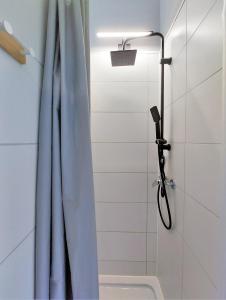 a shower with a blue shower curtain in a bathroom at Krakowska Awangarda - Close to the Old Town in Krakow