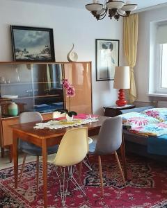 a dining room with a table and chairs and a bed at Modern retro apartament Katowice in Katowice