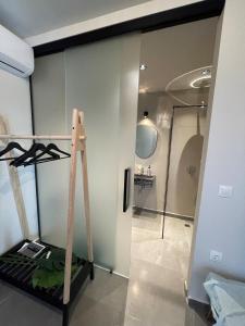 Habitación con escalera, espejo y ducha. en Istoria Boutique Hotel, en Lefkada