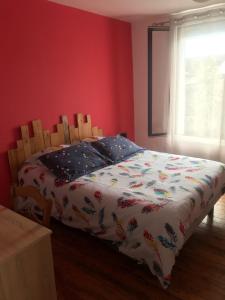 CHAMBRE La Petite VENISE في بونت أودوميه: غرفة نوم مع سرير مع لحاف عليه