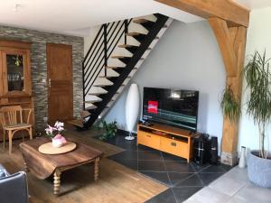 a living room with a staircase and a table at CHAMBRE La Petite VENISE in Pont-Audemer
