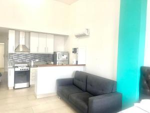 sala de estar con sofá y cocina en Departamento Alassio en Tigre