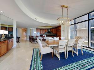 a dining room and kitchen with a table and chairs at Capri #301 in Perdido Key