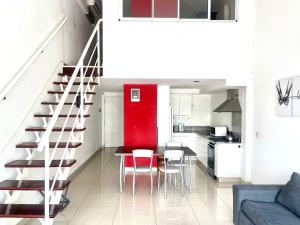 cocina y comedor con pared roja en Departamento Alassio en Tigre