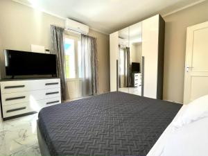 Schlafzimmer mit einem Bett und einem Flachbild-TV in der Unterkunft Villa Anastasia in Forte dei Marmi