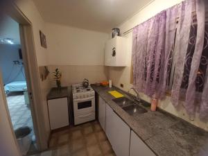 uma pequena cozinha com um lavatório e um fogão em BENDITO AMANECER em La Rioja