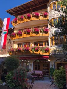 a building with flower boxes on the side of it at Am Dorfplatz Suites - Adults only in Sankt Anton am Arlberg