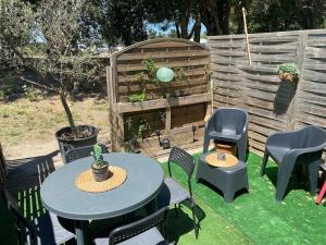 a patio with tables and chairs and a fence at Un duplex pour 4 personne résidence de vacances in Arles