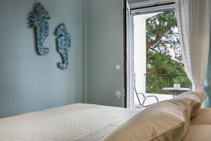 um quarto com uma cama e uma grande janela em Julia's Boutique Suites, near Argostoli. em Travliáta