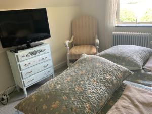 a bedroom with a bed and a television and a dresser at Den Gamle Apotekergaard in Høng