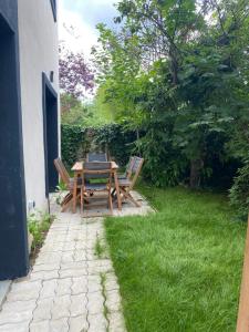 einen Holztisch und Stühle mit einem Laptop darauf in der Unterkunft Joli duplex climatisé à 30min Paris in Montmorency