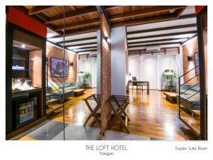 ein Wohnzimmer mit Sofa und Tisch in der Unterkunft The Loft Hotel Downtown Yangon in Yangon