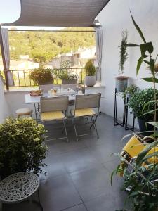 um pátio com uma mesa, cadeiras e plantas em Chambre d hotes "Lilimyna" avec petit déjeuner em Barjols