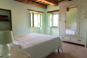 a bedroom with a bed and a cabinet and windows at Il casale dei nonni in Grottazzolina