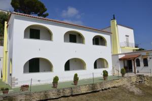 un bâtiment blanc avec des plantes en pot devant lui dans l'établissement U Campagnuolo, à Ischia