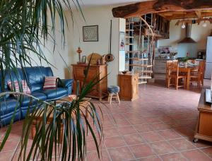 a living room with a blue couch and a table at Les Gîtes de LAURES in Monblanc