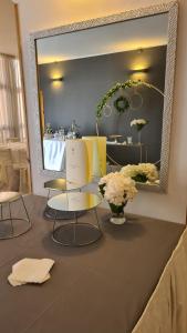 een kamer met 2 stoelen, een spiegel en bloemen bij PEDA Hotel Ristorante Pizzeria in Colletorto