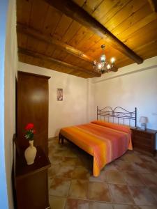 - une chambre avec un lit et un vase avec des fleurs dans l'établissement Nebrodi Holiday House, à San Marco dʼAlunzio