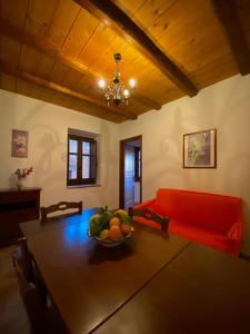 - un salon avec une table et un canapé rouge dans l'établissement Nebrodi Holiday House, à San Marco dʼAlunzio