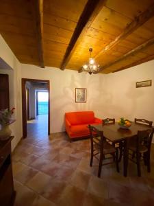 - un salon avec un canapé orange et une table dans l'établissement Nebrodi Holiday House, à San Marco dʼAlunzio