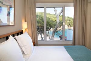 a bedroom with a bed and a large window at Hotel Hostalillo by Escampa Hotels in Tamariu